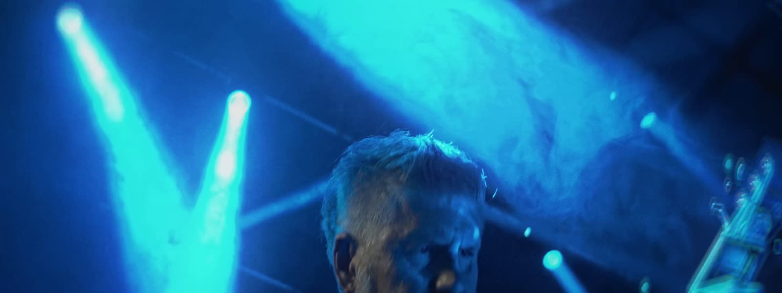 a man standing in front of a blue light