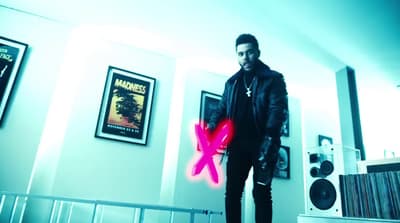 a man standing in a room holding a neon pink object