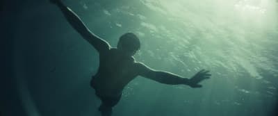a man swimming in the water with his arms outstretched