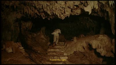 a man standing on steps in a cave