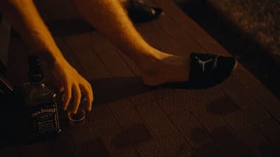 a person sitting on the floor with their feet on a bottle