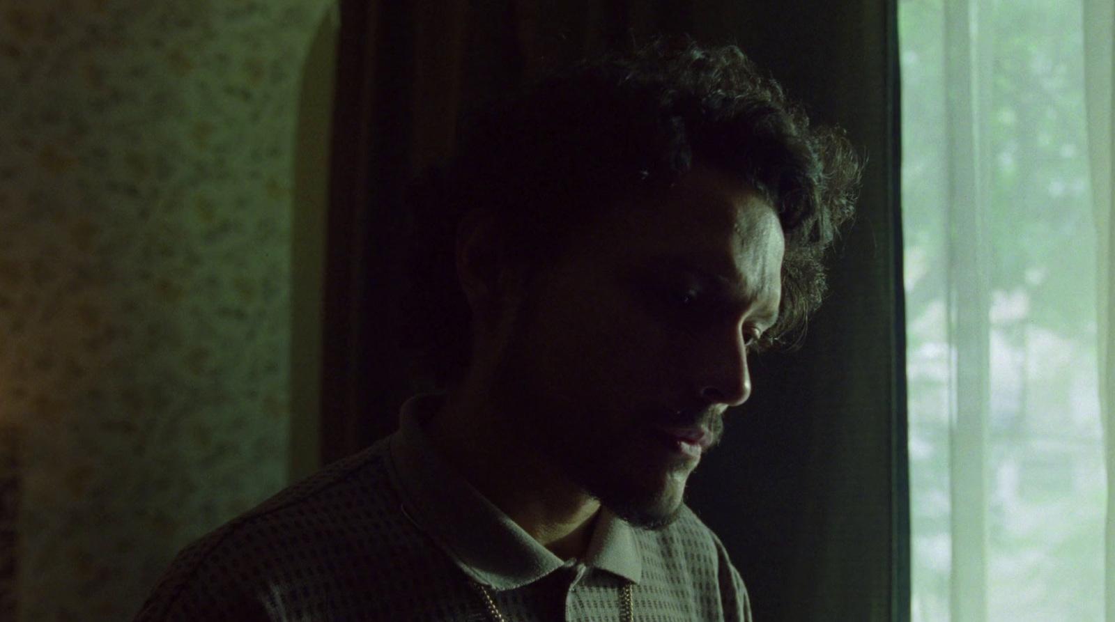 a man standing in front of a window looking at his cell phone