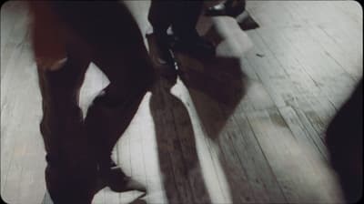 a couple of people standing on top of a wooden floor