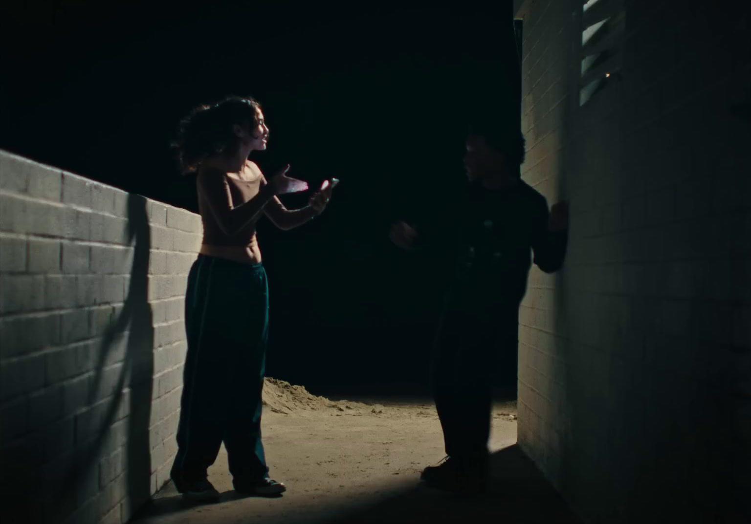 a man and a woman standing next to a brick wall