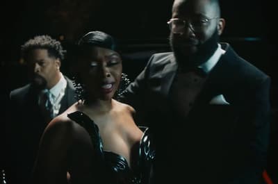 a woman in a black dress standing next to a man in a tuxedo