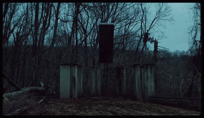 a fence in the middle of a forest at night