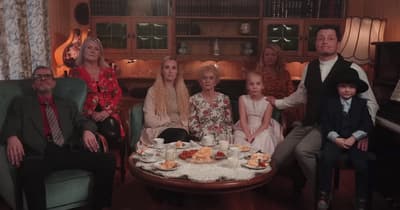 a group of people sitting around a table with food on it