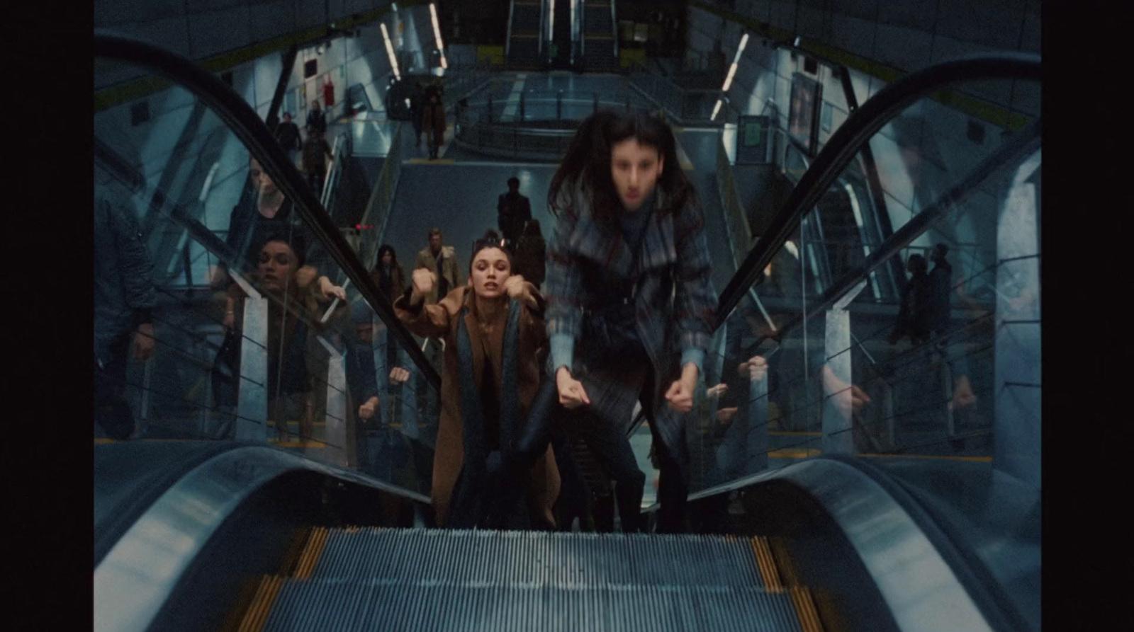 a group of people riding down an escalator