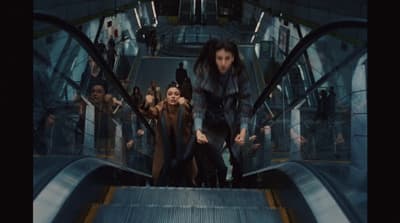 a group of people riding down an escalator