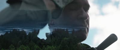 a reflection of a man holding a baseball bat