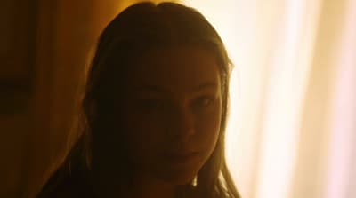 a woman with long hair standing in front of a window
