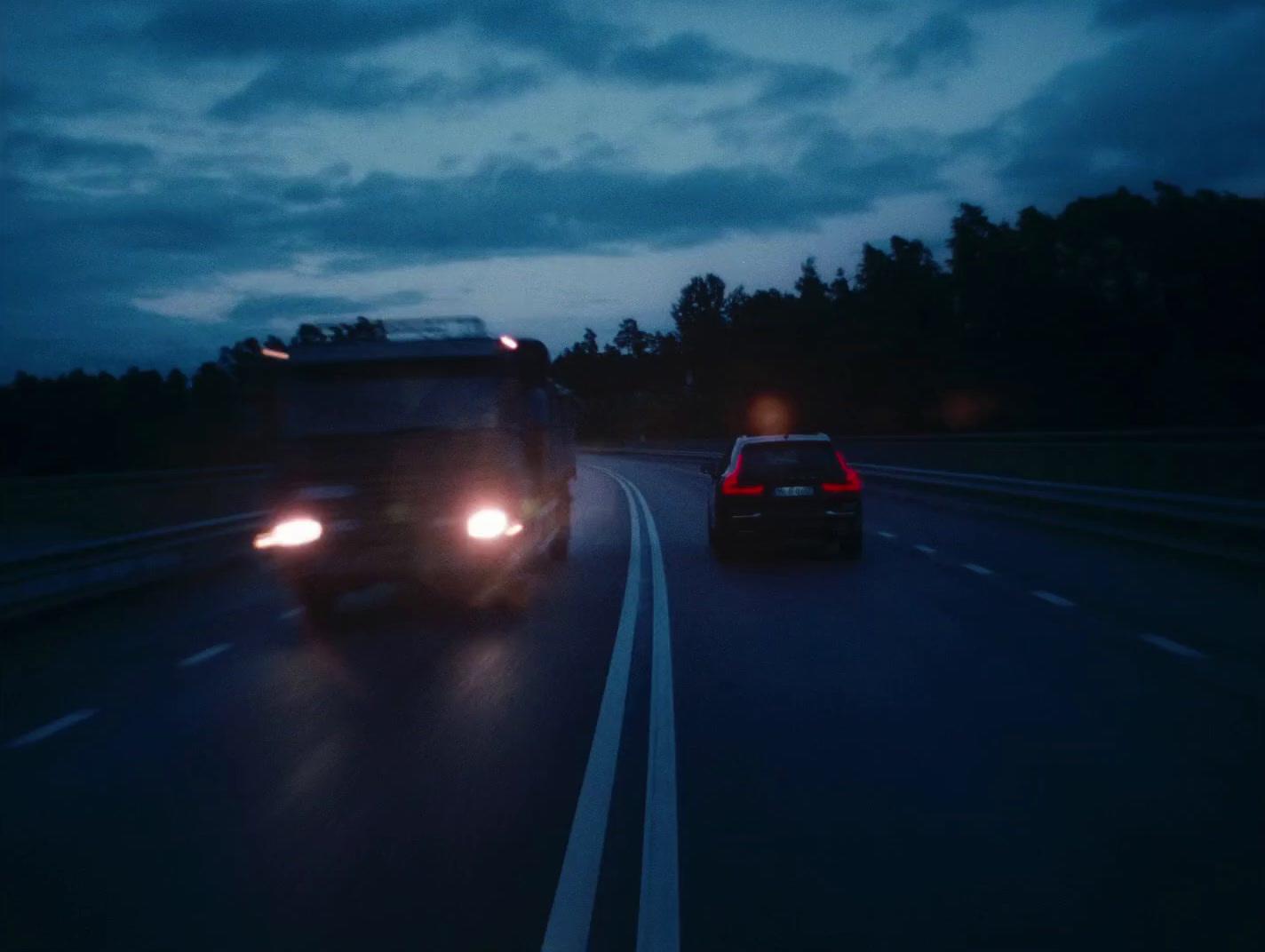 a couple of cars driving down a highway at night