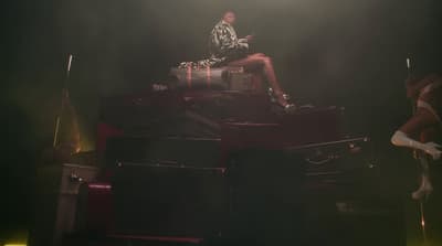 a woman sitting on top of a pile of luggage