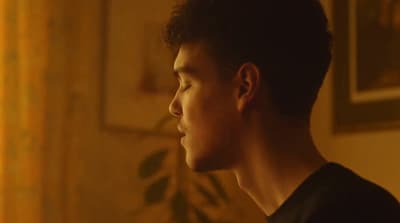 a man in a black shirt looking off into the distance