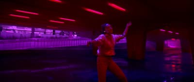 a man standing in a room with red and purple lights