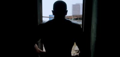 a man standing in front of a window in a dark room