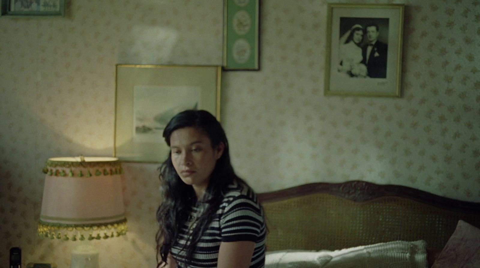 a woman standing in a bedroom next to a bed