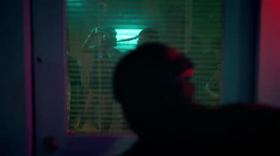 a man standing in front of a window at night