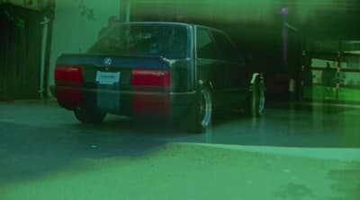 a car parked in a garage next to another car