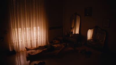 a person laying on a bed in a dark room