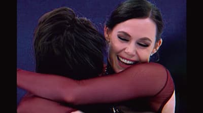 a couple of women hugging each other on stage