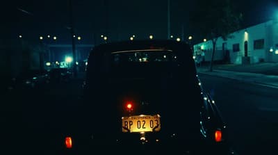 a car parked on the side of the road at night