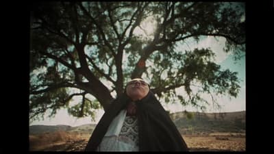 a woman standing under a tree with her eyes closed