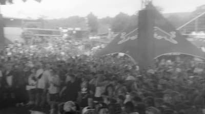 a large crowd of people standing around a stage
