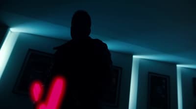 a person in a dark room with a neon heart