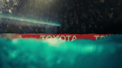 a blurry photo of a toyota sign in the water