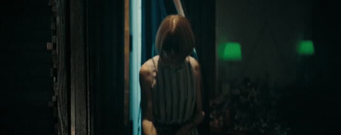 a person standing in a doorway with a green light