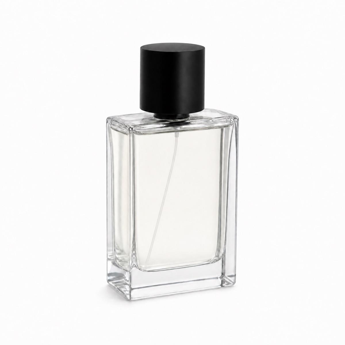 Perfume bottle staged on a marble table by a window, next to a ceramic tray with eucalyptus - After