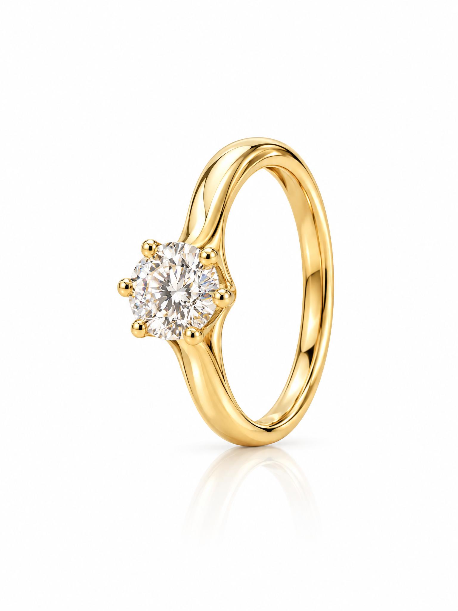 Gold solitaire ring lying on a wooden desk between a laptop and a coffee mug, and the same ring standing upright as a packshot on white - After