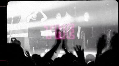 a group of people holding their hands up in front of a stage