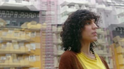 a woman standing in front of a tall building
