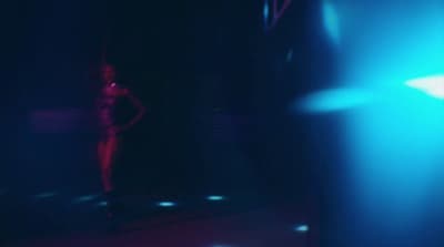 a woman standing in a dark room in front of a mirror