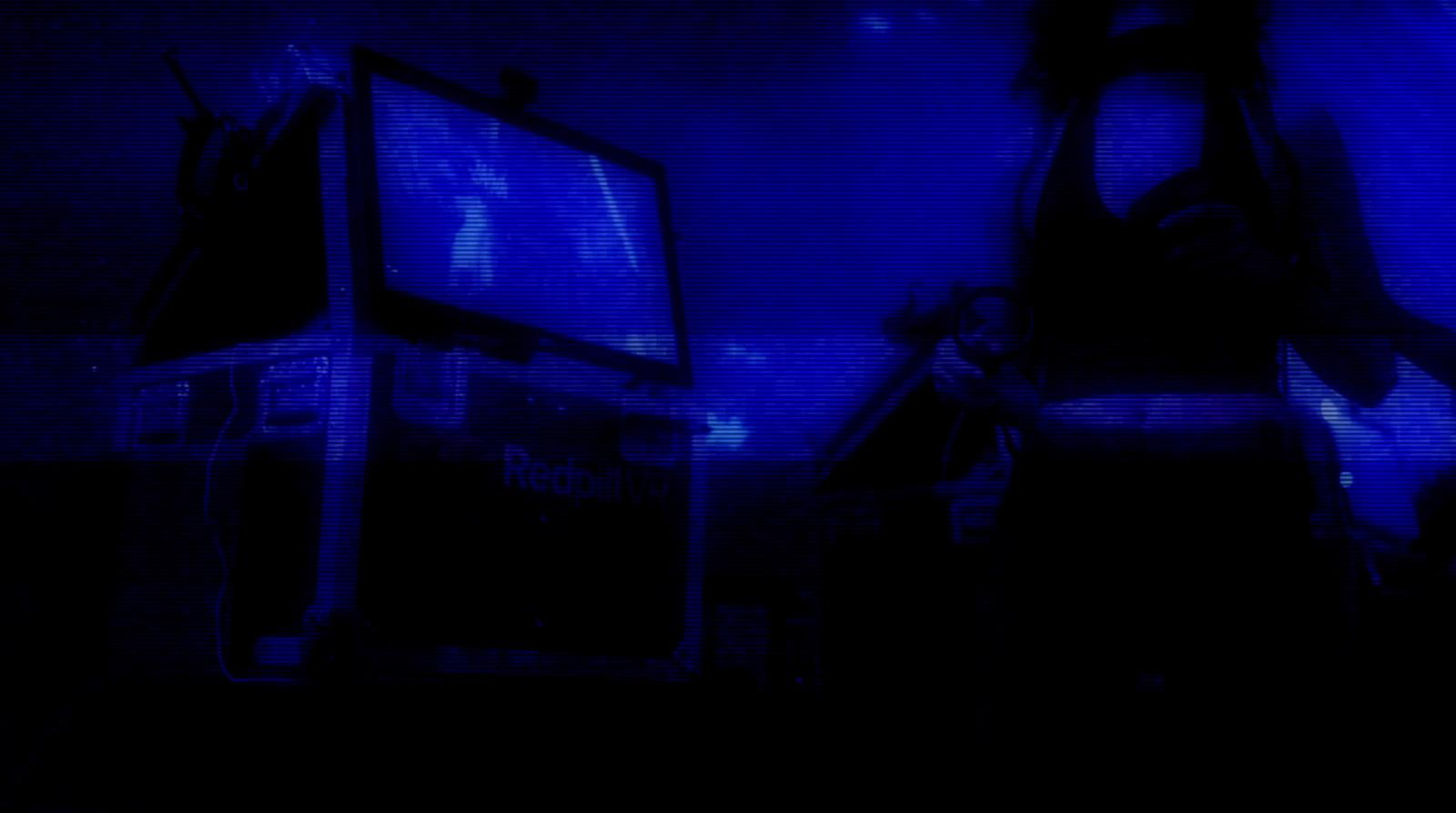 a dark room with a television and a blue screen