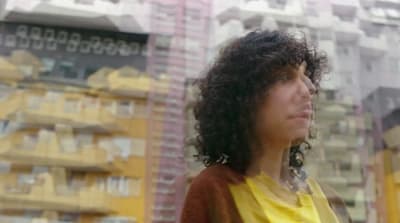 a woman standing in front of a tall building