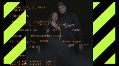 a man and a woman standing in front of a computer screen