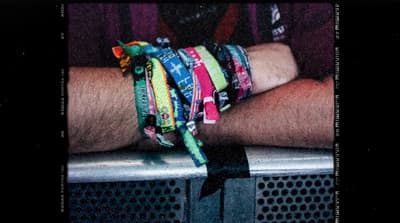 a man's arm with a bunch of bracelets on it
