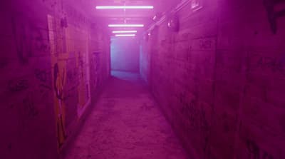 a long narrow hallway with graffiti on the walls