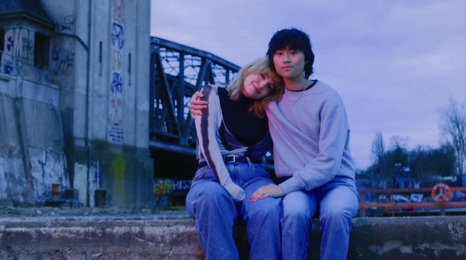 a man and a woman are sitting on a ledge
