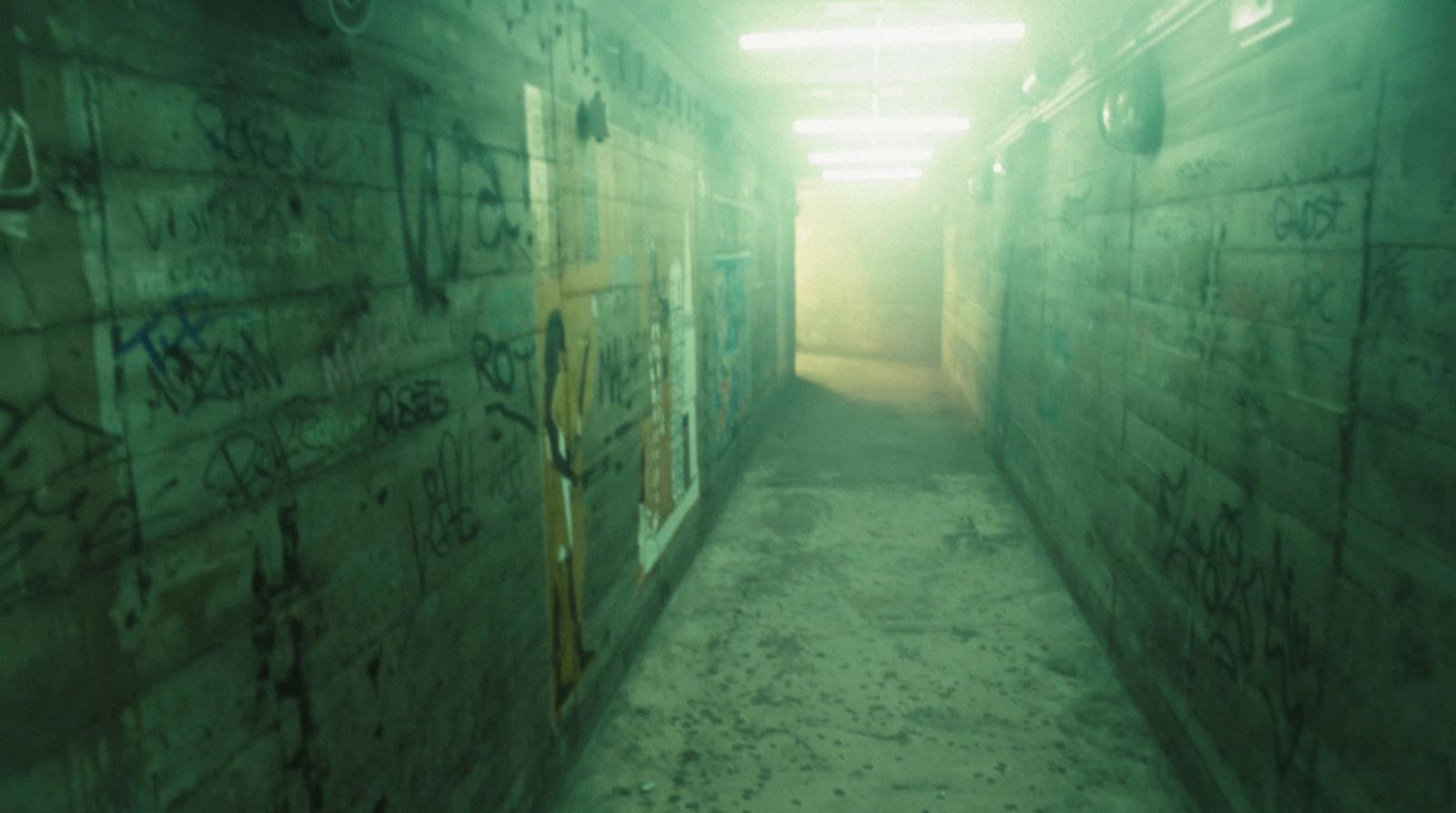 a long narrow hallway with graffiti on the walls