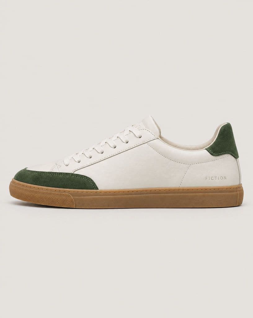 White leather sneaker with green suede panels on a warm gray backdrop, and the same sneaker on a flat peach background - Before